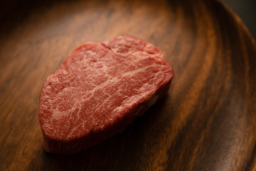 Raw meat on the wooden plate