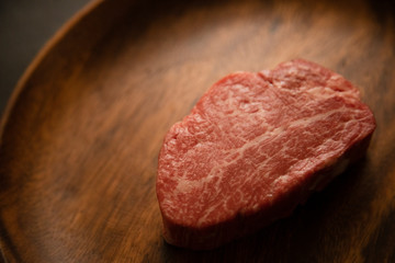 Raw meat on the wooden plate