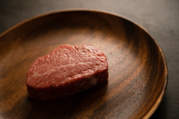 Raw meat on the wooden plate