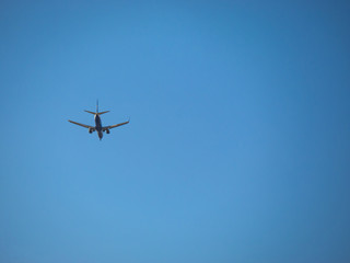Airplane flying over a completely clear blue sky