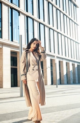 young pretty brunette woman in fashion suit at business building posing cheerful, lifestyle people concept