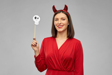 holiday, photo booth and people concept - happy smiling woman in red halloween costume of devil...