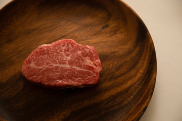 Raw meat on the wooden plate