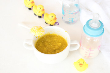 mix rice gruel with  pumpkin healthy foods and milks bottles health care for baby eats breakfast arrangement flat lay style on background white 