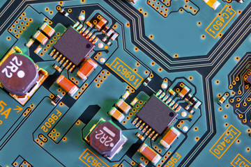 Electronic circuit board with electronic components such as chips close up. Blurry background.	