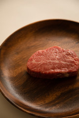 Raw meat on the wooden plate