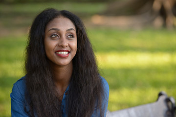 Happy young beautiful African woman at the park outdoors