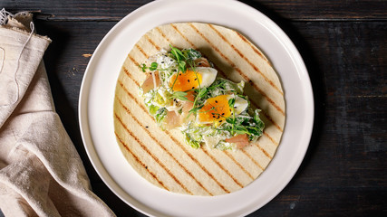 Fresh vegetable salad with smoked chicken, eggs, greens and black sesame seeds, wheat tortillas. Restaurant salad recipe. Top view. Food banner format