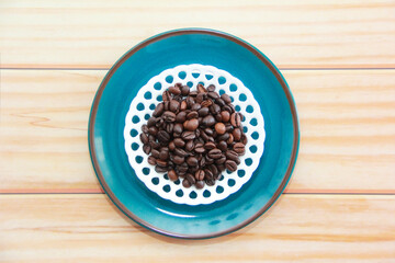natural black coffee beans in a decorative plate