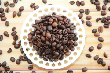 natural black coffee beans in a decorative plate
