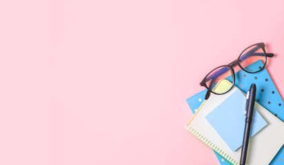 Pink background with notepad, office glasses, pen, place for text. Trend concept. Future. Pink background with notepad, office glasses, pen, place for text.