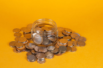 save finances by accumulating them. glass jar on a yellow background