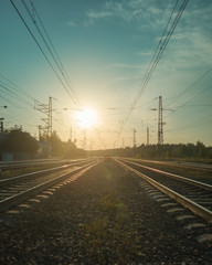 Landscape with railroad tracks and red signal semaphore in the rays of sunset