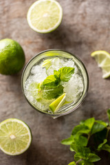 Mojito cocktail drink with white rum lime mint herbs and soda on the bar counter.