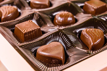 Heap of chocolate candies in a brown box
