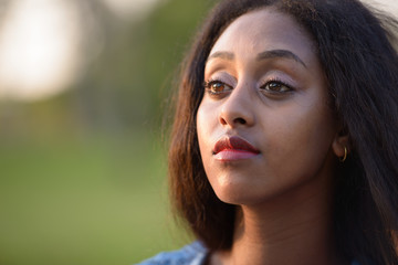 Portrait of young beautiful African woman at the park outdoors