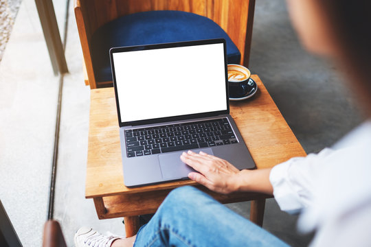 Mockup image of a businesswoman using and touching on laptop touchpad with blank white desktop screen in cafe