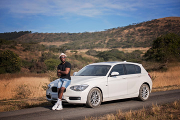 Successful black man with luxury car in the african safari