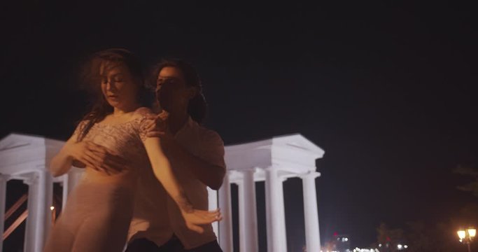 young mixed race couple dancing bachata outdoors during beautiful evening in city 