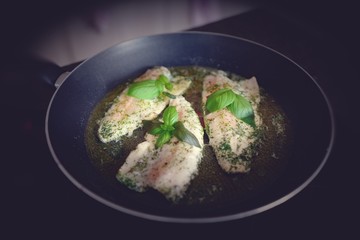 fresh cooking at home - roasted trout in olive oil with basil