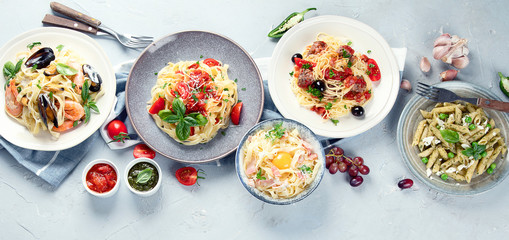 Plates of pastas with different kinds of sauces.