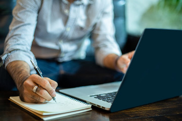 Fototapeta premium Asian businessman Write notes and using laptop for working in home office.