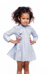 Portrait of a cute little african american girl in a blue dress, isolated on white background