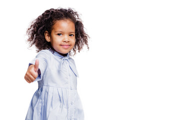 Portrait of pretty little african american girl in blue dress shows gesture, everything is fine, a class sign on white background
