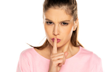 Young angry woman with finger on her lips