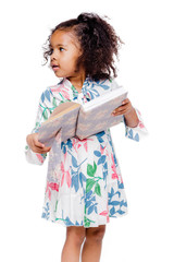 Little cute fashionable african american girl in white floral dress holding a notebook