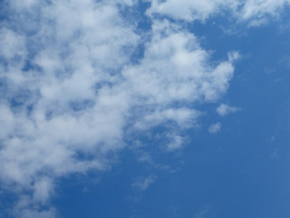 The blue cloudy sky with white clouds background and texture