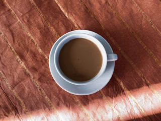 white cup of coffee on a red canvas