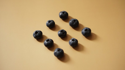 Blueberries are laid out in rows on a gold background - perfectionism concept
