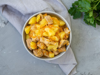 Meat stew with potatoes and carrots. Pork meat stewed with vegetables on a grey background with...