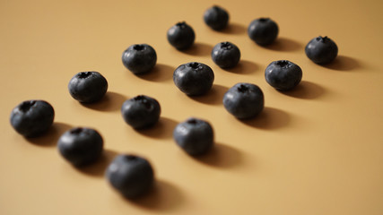 Blueberries are laid out in rows on a gold background - perfectionism concept