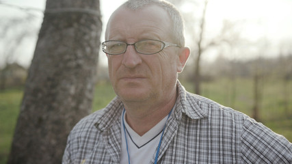 Portrait face young man with glasses look at camera in nature garden green meadow park adult agriculture garden male worker casual one person portrait