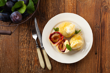 Dumplings with plums, topped with plum sauce or served with cream and sugar.