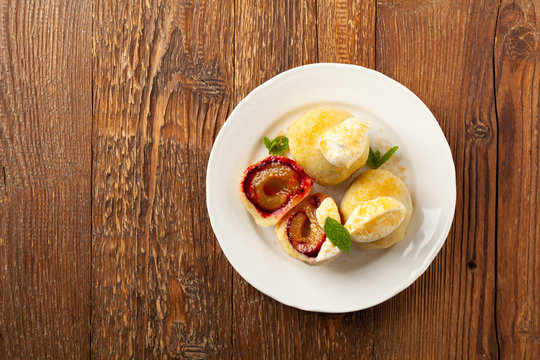 Dumplings with plums, topped with plum sauce or served with cream and sugar.