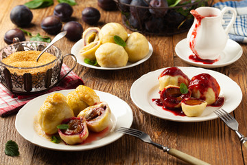 Dumplings with plums, topped with plum sauce or served with cream and sugar.