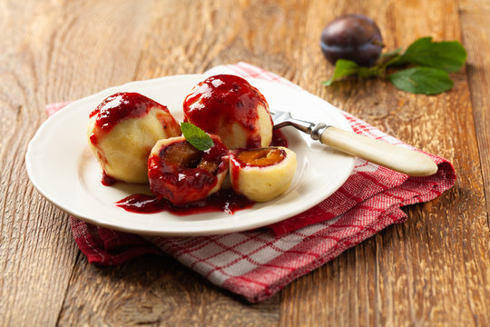 Dumplings with plums, topped with plum sauce or served with cream and sugar.