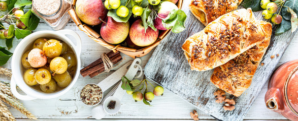 Baking with apple, Freshly baked apple and cinnamon rolls made from puff pastry on a white wooden table. Top view, rustic style, copy space.
