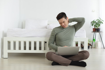 young man stretch relaxing from work with laptop, work from home concept.