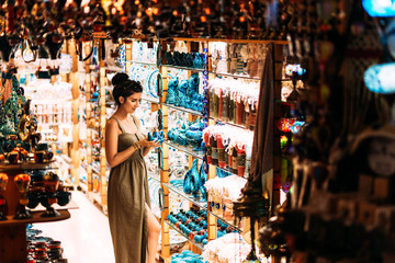 Beautiful girl in a souvenir shop in Turkey. Girl chooses a souvenir Oriental shop. Turkish...