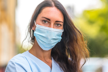 Medical worker posing covering her face with a protective mask