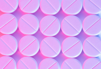 Pattern of white round medical pills in pink light flash