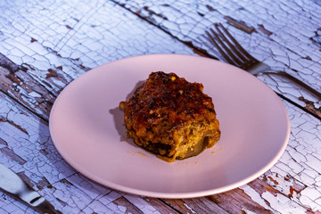  Portion of stuffed aubergines in the oven on rustic wooden table