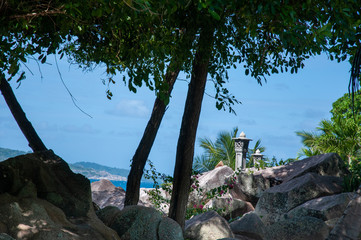 Stone post on the rock over a bay of water in the island of La Digue, Seychelles