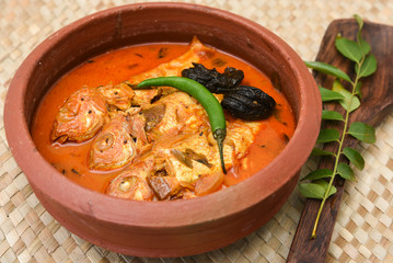 Kerala Masala fish curry in coastal area, Alappuzha south Indian and Sri Lanka, Malaysia. made by marinated mackerel fish, coconut milk, 
 Indian spices. seafood in clay or mud pot.