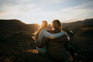 Mother and Daughter enjoying the view after a mountain hike during sunset - Powered by Adobe