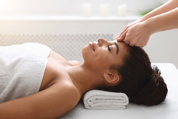 Obraz na płótnie Canvas Therapist making soothing head massage for black lady